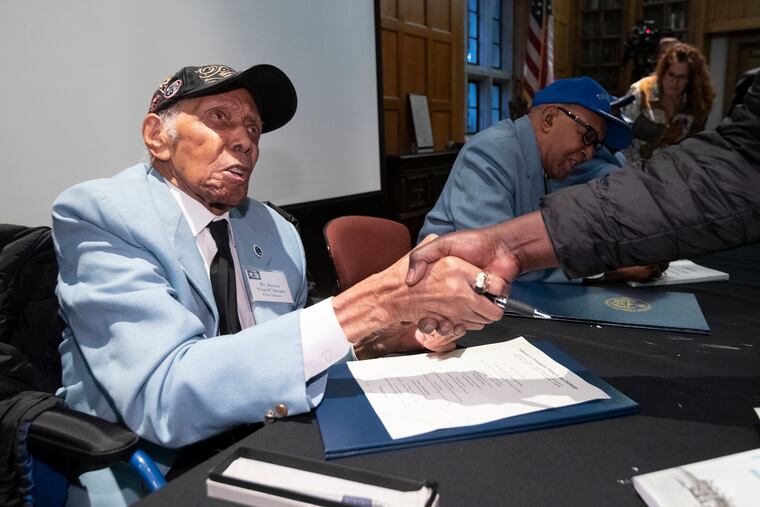 Tuskegee airman and instructor Roscoe “Coach” Draper, 100, a native of Haverford Township, shakes a hand last week at West Chester University after signing a new book about his historic African-American World War II unit.