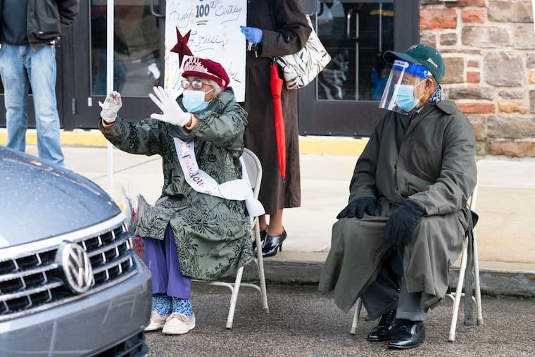 Louise Gray, of Cobbs Creek, left, attends a ride-by parade in honor of her 100th birthday with her brother, Norman Abraham, 97, right, in front of Mt. Carmel Baptist Church, in Philadelphia, Monday, November 30, 2020.