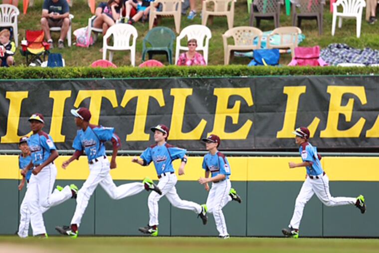 Taney players run onto the field in Williamsport, Pa. before their first game of the 2014 Little League World Series. (David Swanson/Staff Photographer)
