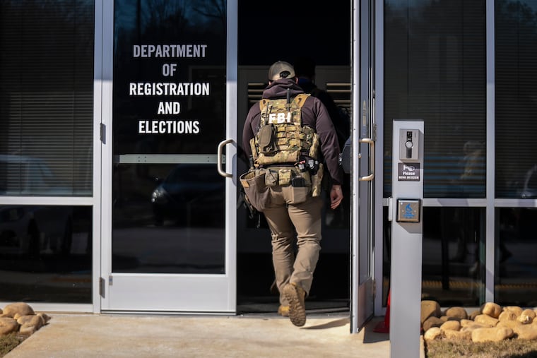 An FBI agent, part of a team executing a search warrant, enters the Fulton County Election Hub and Operation Center in Atlanta in January. For all of Donald Trump’s bluster about rigged elections, he remains the poster child for election interference, writes the Editorial Board.