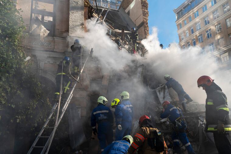 Firefighters work after a drone slammed into a building in Kyiv on Monday.