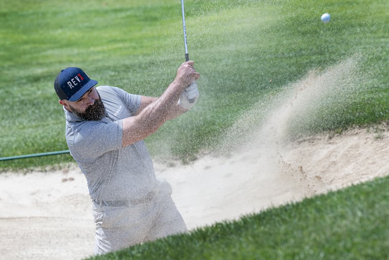 Former Eagles center Jason Kelce hits out of the bunker in the first hole Monday at the Union League Golf Club at Torresdale.