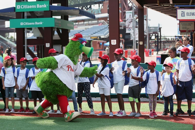 The Phillie Phanatic greets students at a pep rally to remind city residents that Philadelphia School District classes begin Aug. 27 this year — the first time the district has started before Labor Day.