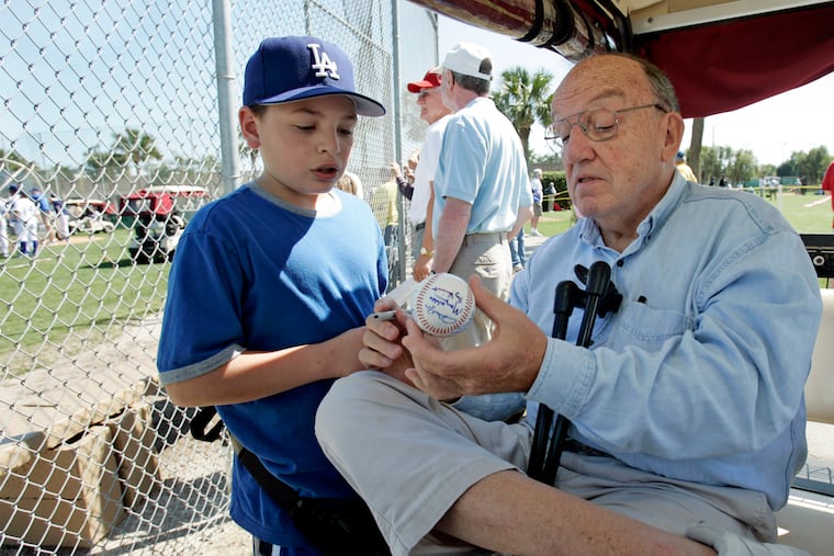 Former baseball commissioner Fay Vincent signs an autograph for a young fan during spring training in 2006. Vincent died Sunday at age 86.
