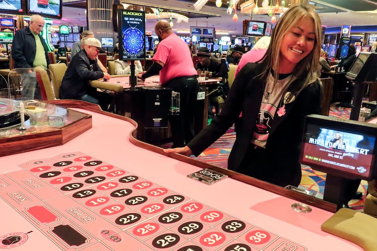 Lee Johnson, a games manager at the Hard Rock casino, checks a roulette table covered in pink felt for Breast Cancer Awareness Month before it opens for use in Atlantic City, N.J., Thursday, Oct. 3, 2024.