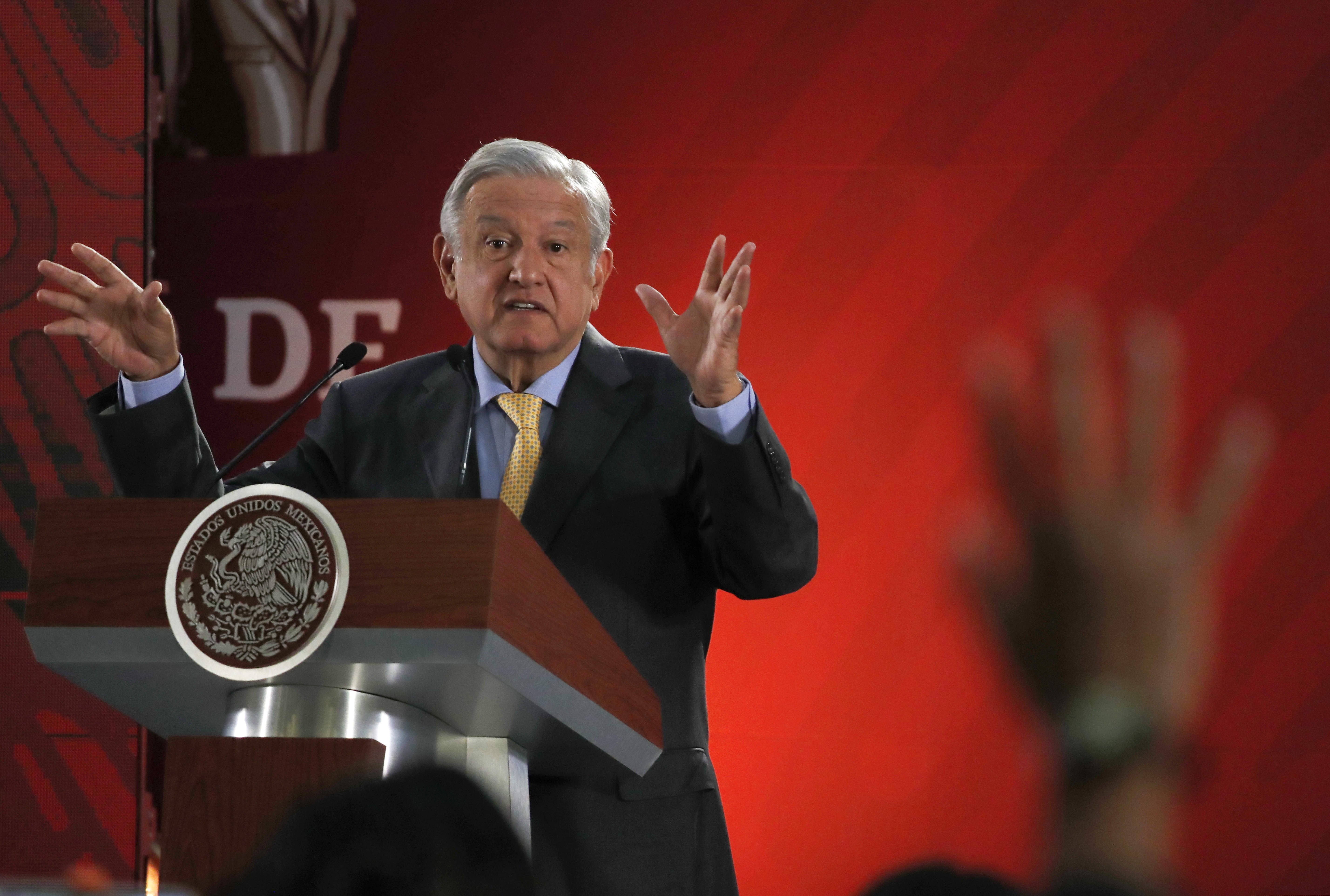In this Friday, March 8, 2019 photo, Mexican President Andres Manuel Lopez Obrador answers questions from journalists at his daily 7 a.m. press conference at the National Palace in Mexico City. Lopez Obrador's first 100 days in office have combined a compulsive shedding of presidential trappings with a dizzying array of policy initiatives, and a series of missteps haven't even dented his soaring approval ratings. (AP Photo/Marco Ugarte)