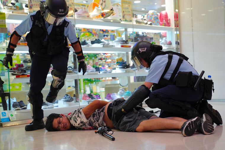 Police detain a young man after fights broke out between pro-China supporters and anti-government protesters at Amoy Plaza in the Kowloon Bay district in Hong Kong, Saturday, Sept. 14, 2019.