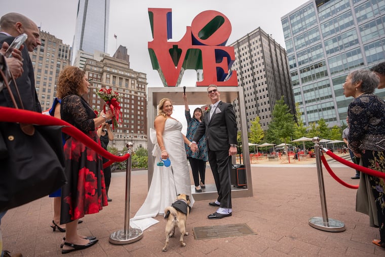 Katherine Ross, left, and John Pacewicz, right, get married in Love Park surrounded by friends and family and their dog Hoagie, in Philadelphia, October 8, 2025.