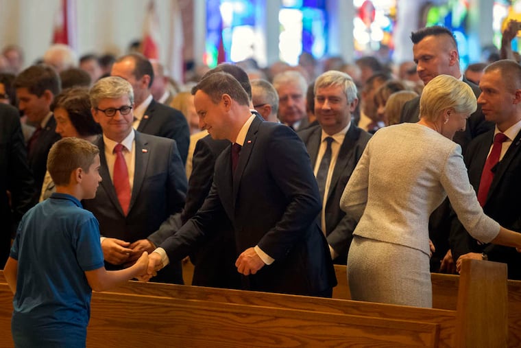 Polish President Andrzej Duda (center) and wife Agata Kornhauser-Duda during the sign of peace at the National Shrine of Our Lady of Czestochowa in Doylestown.