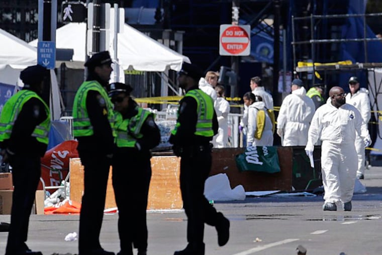 Police and investigators work on Boylston Street, near the finish line of Monday's Boston Marathon, in Boston, Wednesday, April 17, 2013. (AP Photo/Charles Krupa)