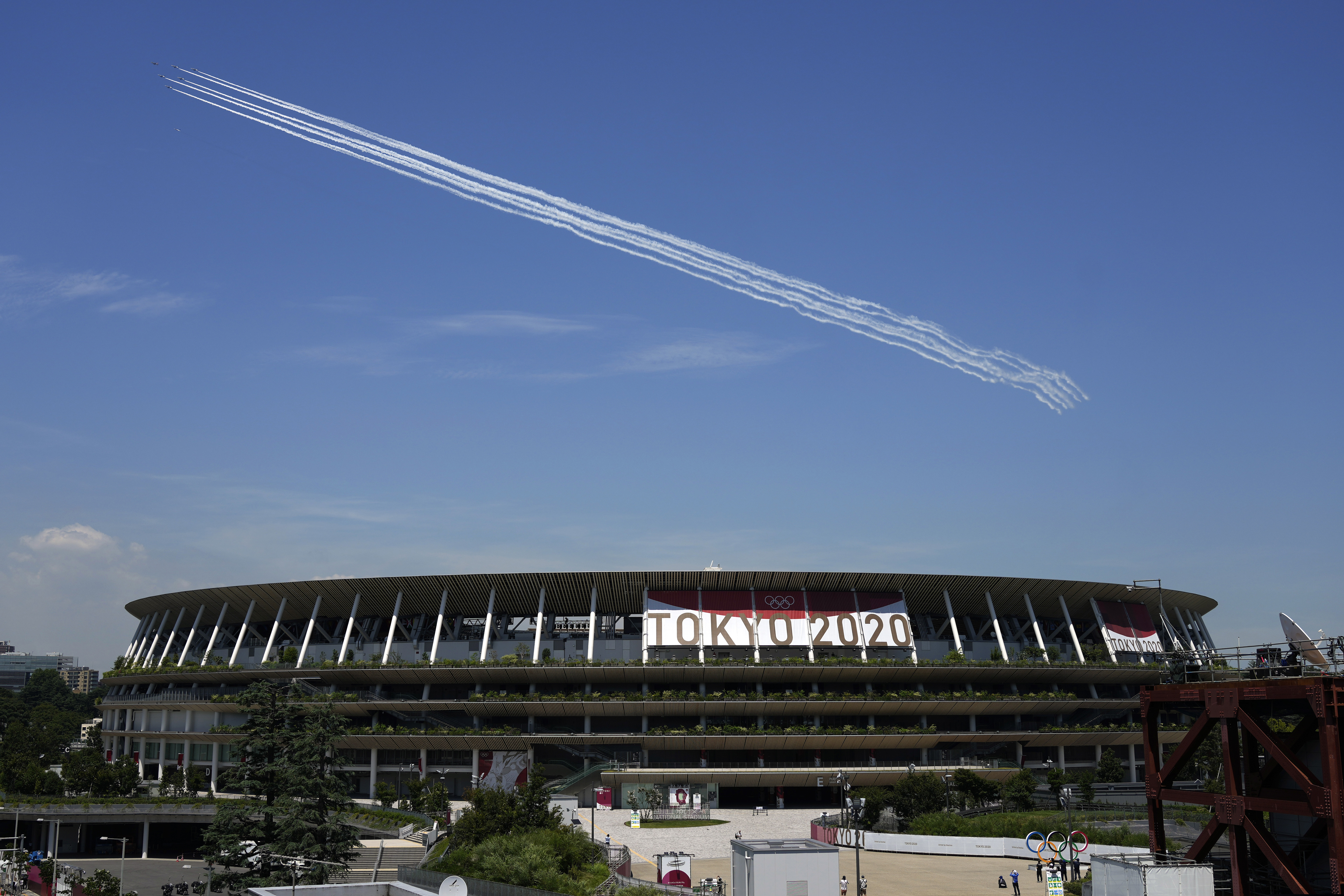 Blue Impulse of the Japan Air Self-Defense Force flies over the main National Stadium in Tokyo, which will host the opening ceremony for the Summer Olympics on Friday.