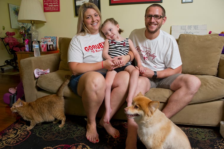 Mindy and David Hoffman hold their daughter Ruby, 4, in their York, PA home.