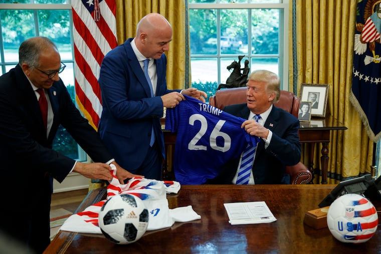 Former United States Soccer Federation president Carlos Cordeiro, left, and FIFA president Gianni Infantino present President Donald Trump with soccer jerseys during a meeting in the Oval Office in 2018.