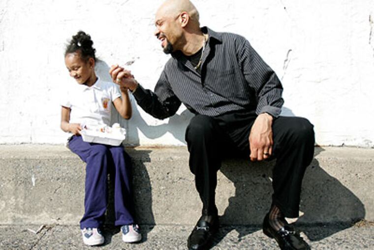 James Wall, 48, steals the walnuts off the banana split his daughter Nevaeh Wall, was enjoying in Friday's sun. (David Swanson / Staff Photographer)