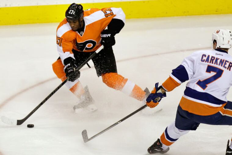 Wayne Simmonds (17) moves the puck past the Islanders' Matt Carkner (7) in the third period of an NHL hockey game, Saturday, Nov. 23, 2013, in Philadelphia. Flyers won 5-2. (Laurence Kesterson/AP)