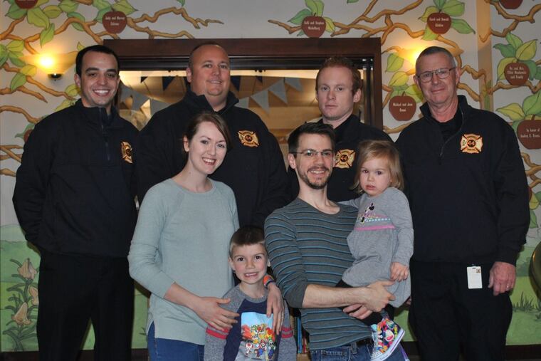 Back row: Firefighters Vince Procopio; Mike Norman; Dan Traband, Jr.; and Bob Tracey. Front row: Krista, Isaiah, Kevin, and Aria Blackburn.