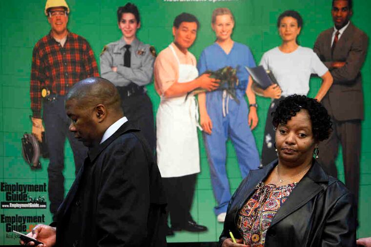 Job seekers Donald Alexander and Felicia Gayden wait in line at a job fair in Livonia, Mich. While the weekly number for unemployment claims was up, the four-week moving average dropped to a two-year low. Story, D3.