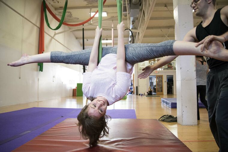 Head coach Adam Woolley of the Philadelphia School of Circus Arts gives staff writer Alexandra Villarreal an assist on the sling.