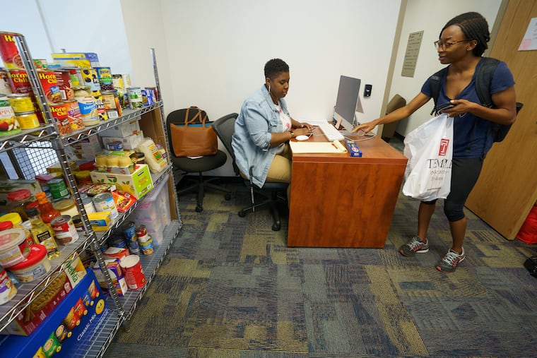 Student Volunteer Kourtney Thompson, center, assists Sharon Okune with her groceries at the Temple University food pantry, in Philadelphia, Thursday, August 09, 2018.