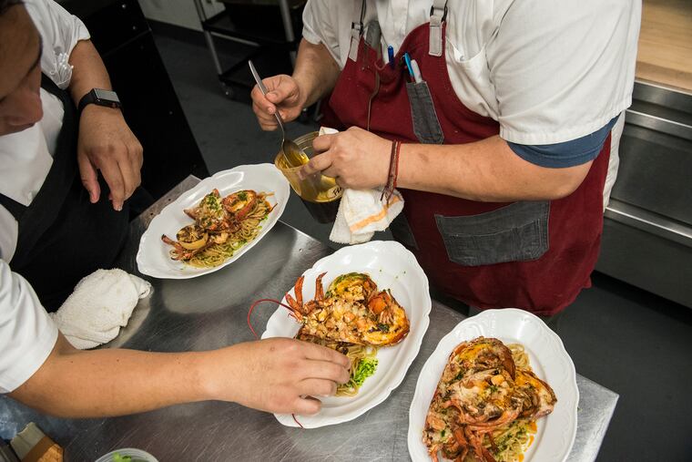 Chefs Leo Forneas (left) and Wesley Fields prepare lobster fra diavolo at Harp & Crown restaurant for menu testing of the future Giuseppe & Sons.