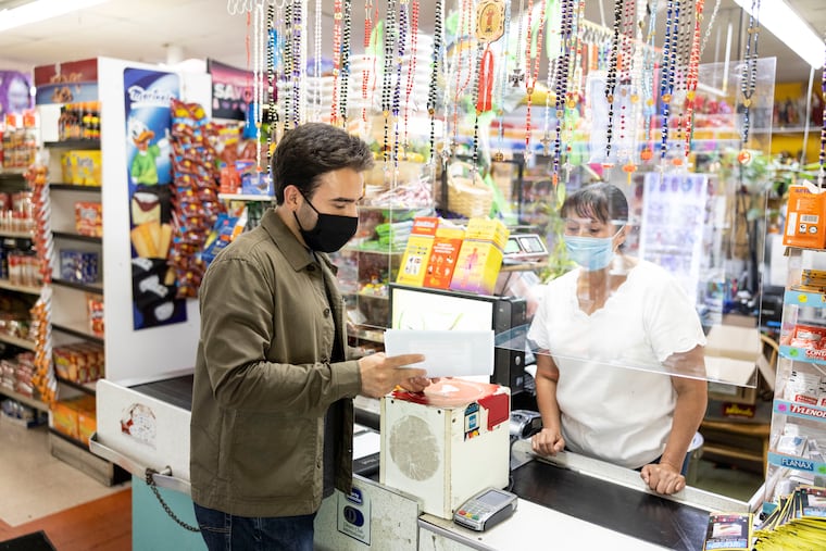 Jovany Ochoa, a COVID-19 ambassador with HealthNet of Rock County, Wis., speaks with cashier Maria Gonzalez about the coronavirus vaccine at the La Mexicana Grocery Store in Beloit, Wis., last week.