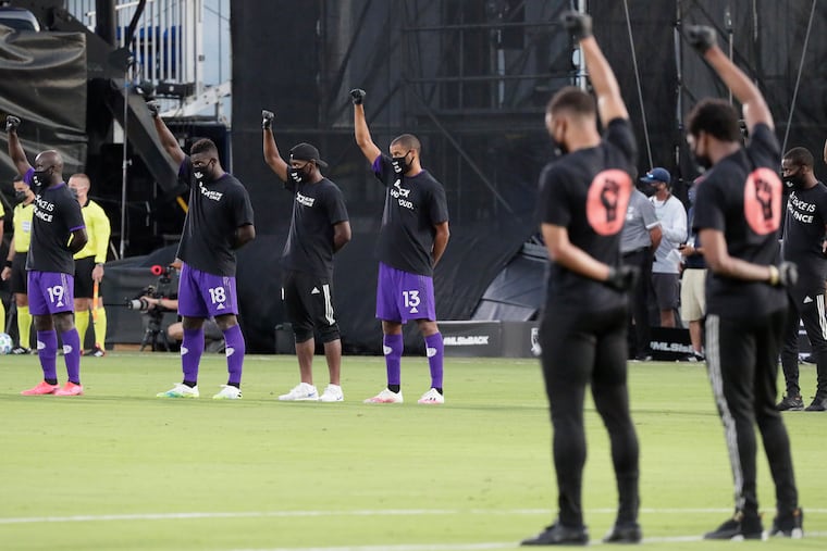 Orlando City players joined players from other teams across MLS to raise their fists in the air in solidarity before the kickoff of MLS' tournament opener in Orlando.