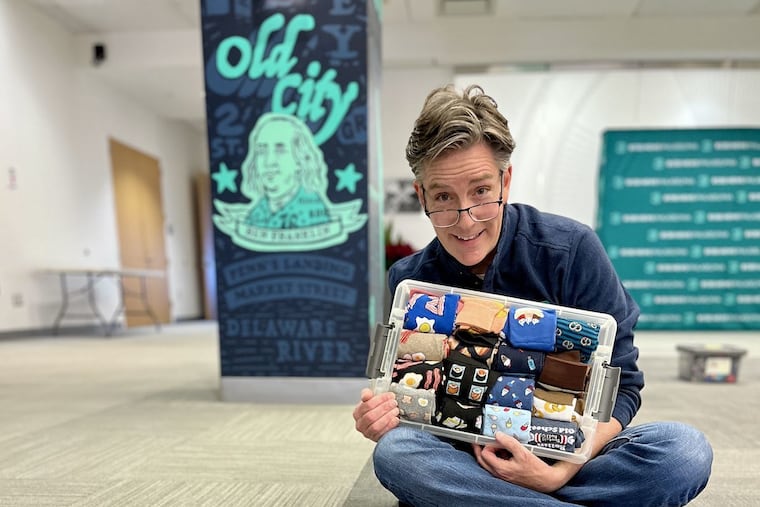 Jim Donovan holds up a box filled with eccentric socks that were given to him over his 22 years at CBS Philadelphia. He received the Guinness World Record for the largest collection of socks on Dec. 8, 2025.