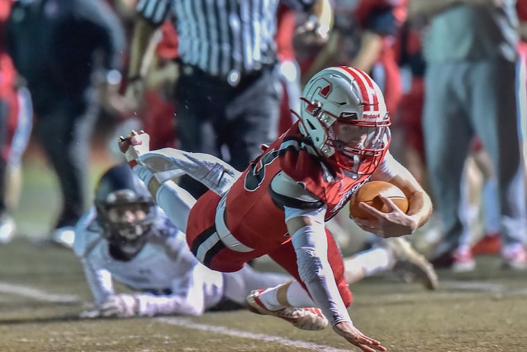 Archbishop Carroll senior quarterback Nick Lamey dives for yardage in the Patriots' 34-28 win over New Hope Solebury in the District 12/District 1 subregional of the PIAA Class 3A state tournament.