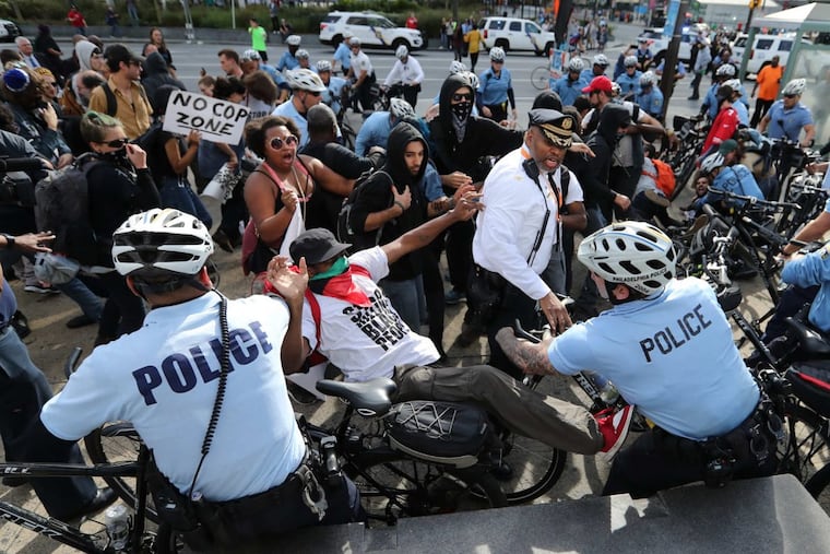 Protestors against police brutality skirmish near the controversial Frank Rizzo statue outside the Municipal Services Building across from City Hall, Philadelphia on Saturday, October 21, 2017. Protests were taking place during the Major Cities Chiefs Association and the International Association of Chiefs of Police convention at Pennsylvania Convention Center.