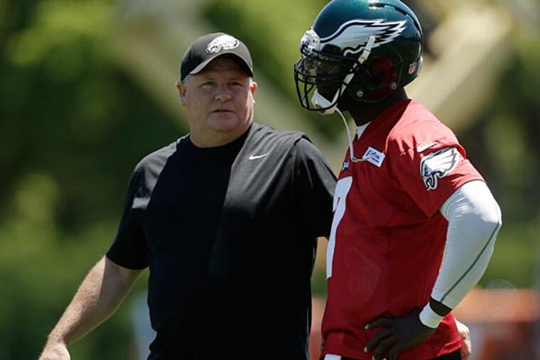 Philadelphia Eagles head coach Chip Kelly, left, talks with quarterback Michael Vick during NFL football practice at the team's training facility, Tuesday, June 4, 2013, in Philadelphia. (AP Photo/Matt Rourke)