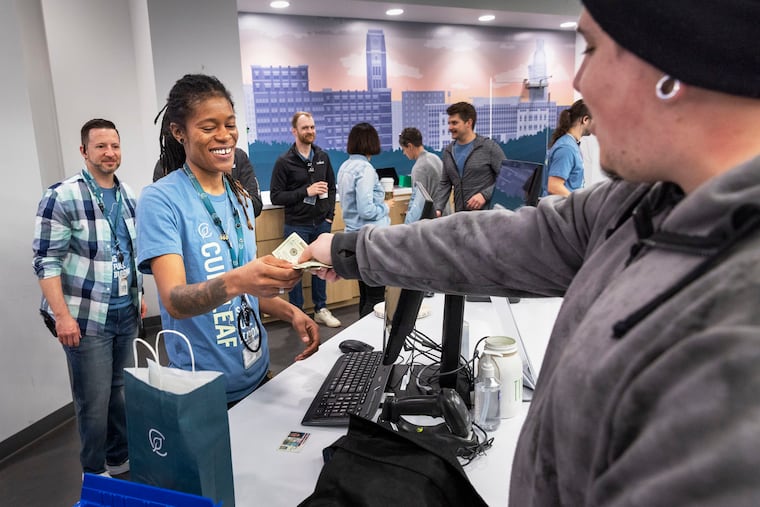 Justin Dugary of Barrington, N.J., pays for his purchase at Curaleaf in Bellmawr, N.J. He lined up at midnight to be the first person in line.