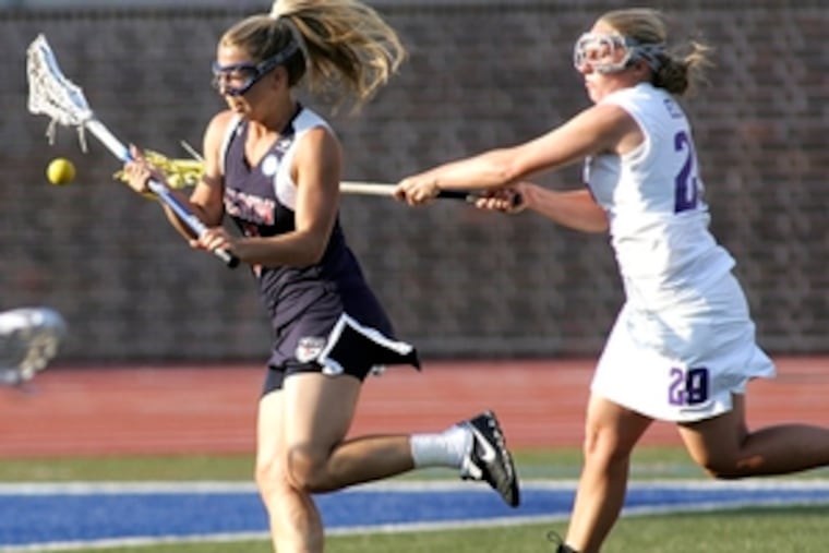 Northwestern's Annie Elliott (right) tries to knock ball away from Penn's Kaitlyn Lombardo.