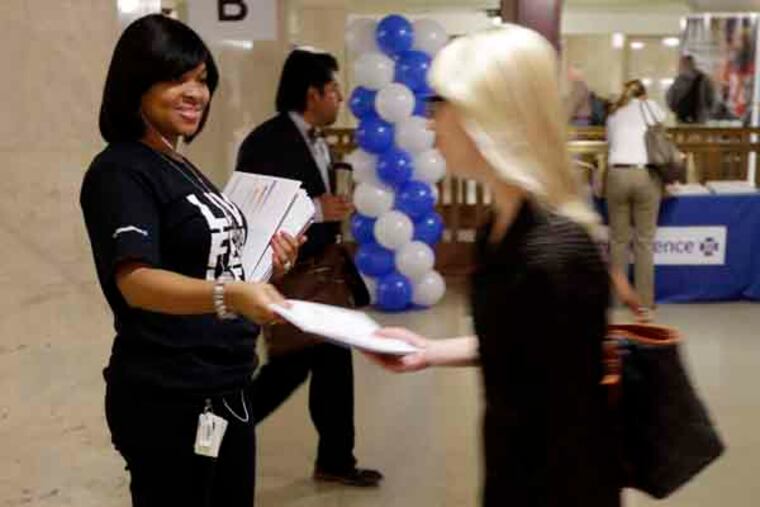 Wendy Jackson, left, and others with Independence Blue Cross mark the opening health insurance exchange by providing information on health car reform at Suburban Station Tuesday, Oct. 1, 2013, in Philadelphia. Tuesday is the first day of the open enrollment period for new health insurance options under the 2010 federal health care law. (AP Photo/Matt Rourke)