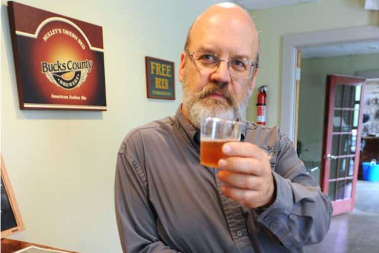 Bucks County Brewery owner Andrew Knechel samples the sprits he and his business partner Sean Tracy from Hewn Spirits at their Pipersville, Pa., establishment.