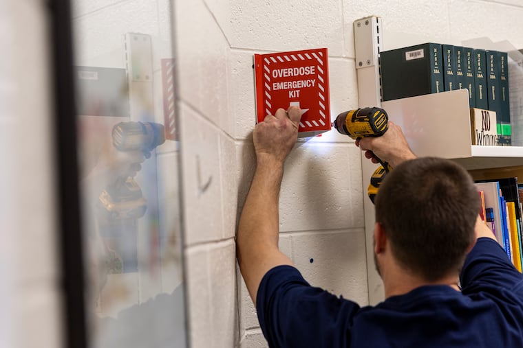 A worker installing the first overdose emergency kit with Narcan nasal spray Thursday at the Highland Regional High School Library in Blackwood, Camden County.