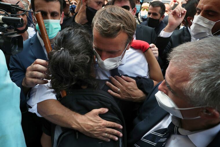 French President Emmanuel Macron hugs a woman as he visits the Gemayzeh neighborhood, which suffered extensive damage from the explosionTuesday that hit the seaport of Beirut.