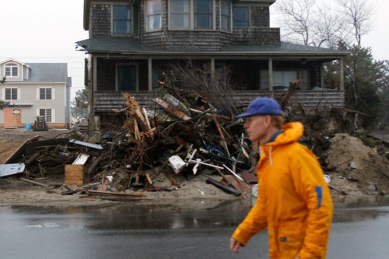 Storm debris was stacked high outside a home in Mantoloking, Ocean County, two months after Hurricane Sandy struck in October 2012. (YONG KIM/Staff Photographer)