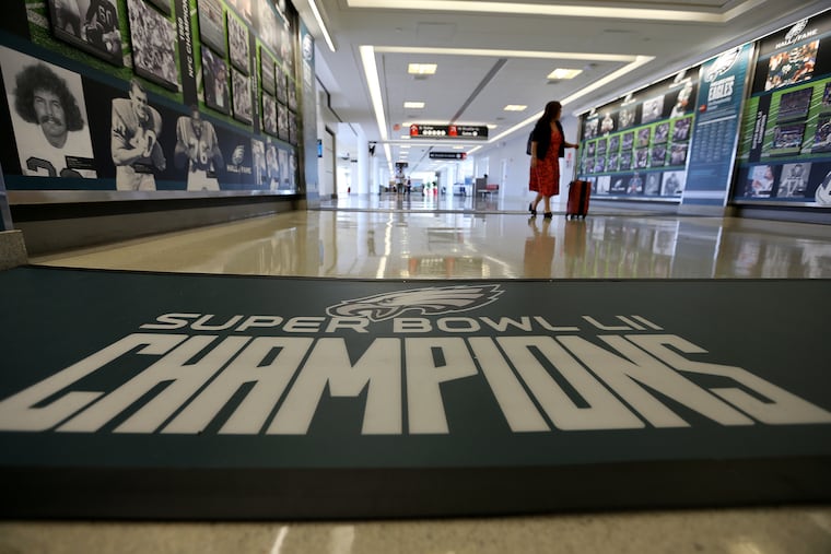 A passenger looks at the new exhibit celebrating the Eagles' championship season at Philadelphia International Airport on June 25, 2018. The exhibit is located in the A East terminal and will be on display for a year.