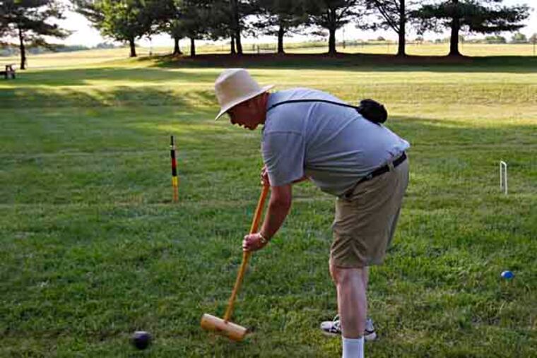 Jim Briggs sends his croquet ball towards a wicket. ( MICHAEL S. WIRTZ / STAFF PHOTOGRAPHER ).