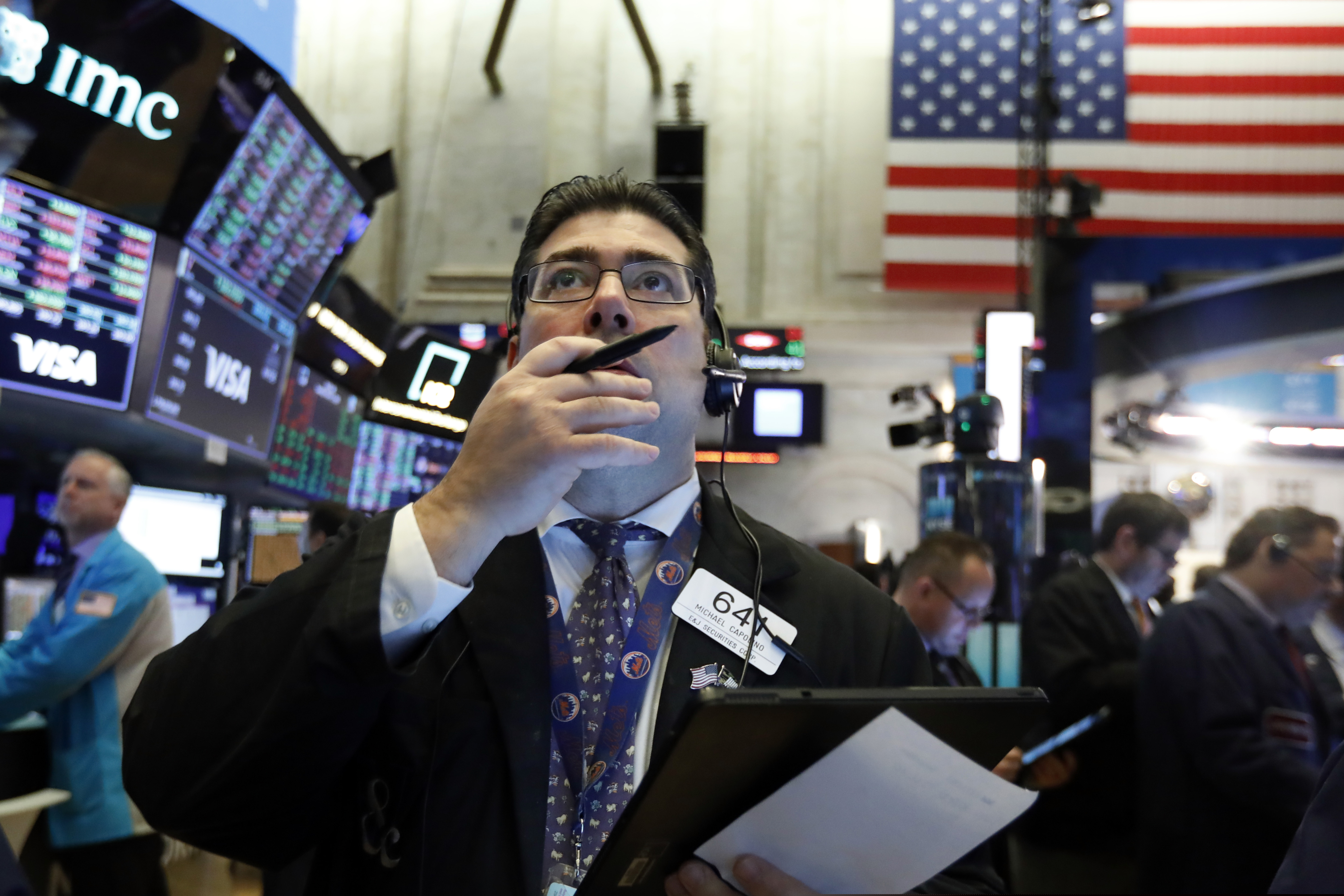 Trader Michael Capolino works on the floor of the New York Stock Exchange. Stock markets continued to fall even after the surprise fed rate cut, which mutual funds giant Vanguard called a high risk bet.