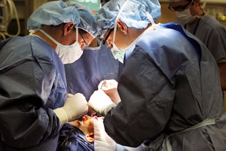 Scott Bartlett (left), chief of plastic surgery, and Chris Derderian, a craniofacial fellow, perform surgery on Gerard McGrenaghan, 17, of Gloucester County, at Children's Hospital of Philadelphia. (Sarah J. Glover / Staff Photographer)
