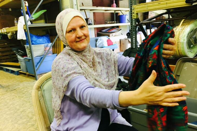 Renata Alkurdi of Narenj Tree Foundation, a Norristown-based charity, which is responding to the Syrian refugee crisis, folds a donated shirt destined for shipment to a Middle East refugee camp. (MICHAEL MATZA/Inquirer Staff)