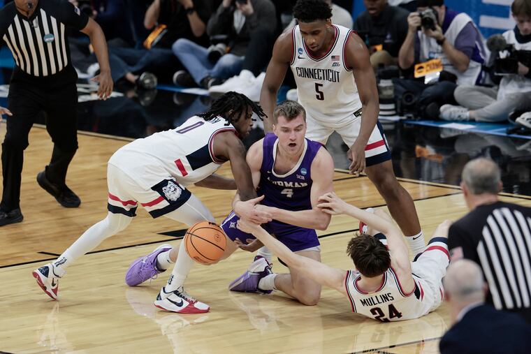 Furman’s Ben Vander Wal battles UConn players for a loose ball during the NCAA Tournament at Xfinity Mobile Arena in Philadelphia on Friday.