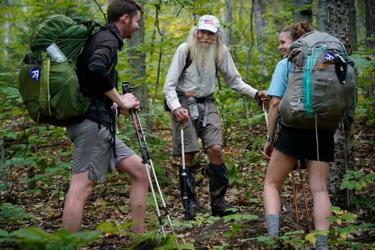 M.J. Eberhart (center) shares trail information with a pair of thru-hikers on the Appalachian Trail in Gorham, N.H., in September. Eberhart, who goes by the trail name of Nimblewill Nomad, is the oldest person to hike the entire 2,193-mile Appalachian Trail.
