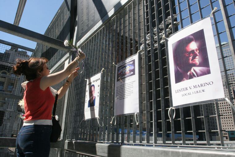 Kathy Haberman places a flower and card in memory of her daughter Andrea Haberman on a gate with other memorial images surrounding ground zero, the site where the World Trade Center once stood in New York, Saturday, Sept. 10, 2005. Andrea Haberman lost her life in the September 11, 2001 World Trade Center attacks. As Sunday's 21st anniversary of the terror attacks approaches, Mohammed and four other men accused of 9/11-related crimes still sit in a U.S. detention center in Guantanamo Bay, their planned trials before a military tribunal endlessly postponed.