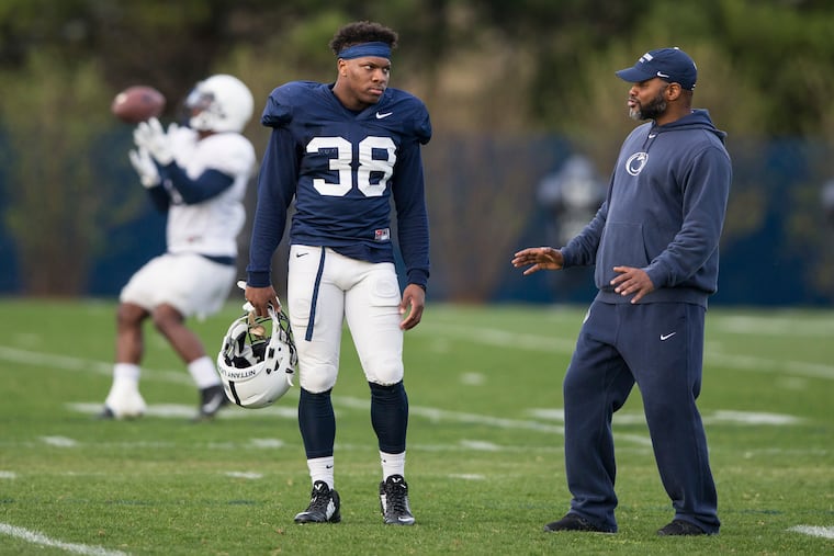 Lamont Wade (left) talks with a coach during an April 2017 practice.