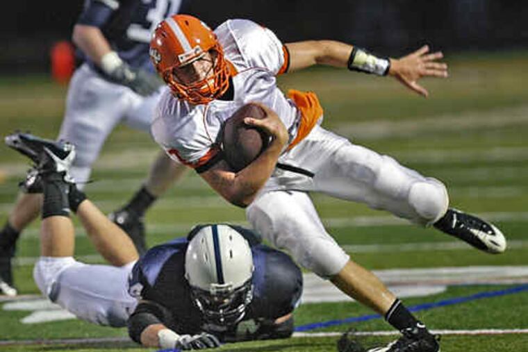 Cherokee quarterback Andrew Martin is tripped up by Shawnee defender Dillon Lucas (on ground) in the first quarter.