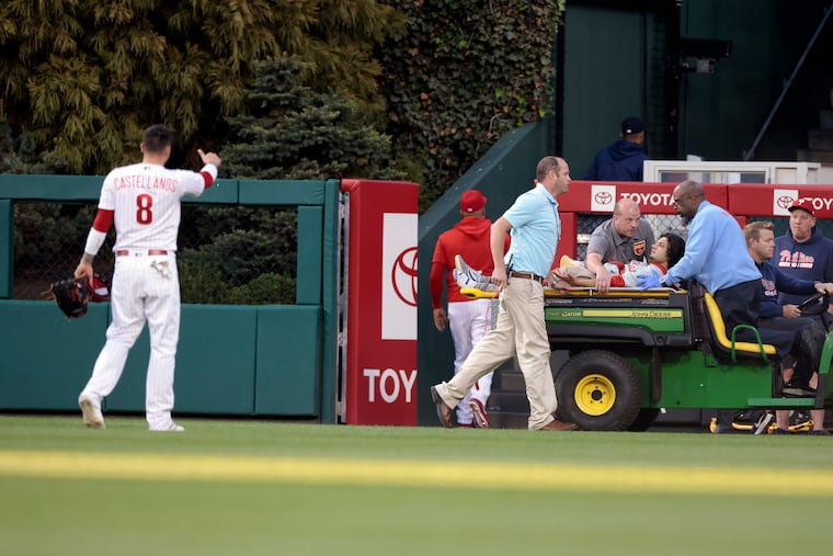 Phillies outfielder Nick Castellanos gives a thumbs up as the fan who fell into the bullpen is carted away at Citizens Bank Park.