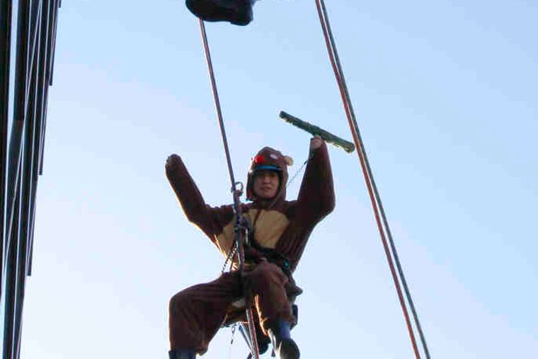 JUNJI TSUDA (top) and Akihiro Kondo dress as Santa Claus and reindeer as they wash windows at a Tokyo mall yesterday.