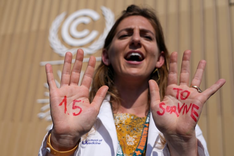 A demonstrator shows her hands reading "1.5 to survive" at a protest advocating for the warming goal at the COP27 U.N. Climate Summit, Wednesday, Nov. 16, 2022, in Sharm el-Sheikh, Egypt.